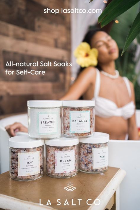 A tan Pacific Islander girl relaxing in a tub. She is wearing a white bikini and yellow hibiscus flower in her hair. In front of her is a table with all 5 of LA SALT CO's signature salt soaks, including Breathe, Balance, Dream, Joy and Zen. Sunday Rest, Skincare Products Photography, Facial Steaming, Perfume Photography, Single Humor, Body Care Products, Bath Essentials, Body Spa, Selling Candles