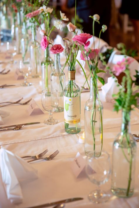 Wine Bottle Bud Vase Wedding, Flowers In Glass Bottles Centerpieces, Flower In Glass Jar Table Decorations, Glass Bottle Flower Arrangements, Wine Bottle With Flowers Centerpieces, Flowers In Wine Bottles Wedding, Wine Bottle Flower Arrangements Wedding, Wine Bottle As Vase, Simple Wine Bottle Centerpieces