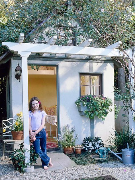 A few extra architectural features add grown-up style to this playhouse. Used in place of an overhanging roof, a trellis can shelter the front door and train a flowering plant for shade. Playhouses can be petite or full-height; the latter provides plenty of ceiling space for a get-away-from-it-all loft. Window boxes offer a low-key way to integrate plants into a playhouse; this one is painted the same color as the trim work for visual continuity. Wiring for electricity adds costs; instead, c... Loft Playhouse, Outdoor Playhouses, Shed Playhouse, Playhouse Ideas, Potting Benches, Small Yard Landscaping, Small Garden Landscape, Build A Playhouse, Garden Houses