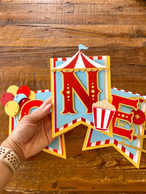 "Circus High Chair Banner Celebrate your little one with this beautifully handcrafted circus highchair banner.  This highchair banner is handcrafted with premium cardstock. It measures at 18 in wide.  My estimated shipping time may not be accurate. Whatever date is listed under \"Personalization\" is the earliest date I'm taking orders for. It is very important that I have your date! If no date is left (or it is farther out) your order will ship closer to my max shipping time, in which case the Diy Circus Party Decorations, Circus Birthday Banner, Diy Circus Decorations, Carnival Decorations Ideas, Carnival Birthday Party Decorations, Circus Theme Decorations, Circus Theme Party Decorations, Circus Party Decor, Carnival Banner