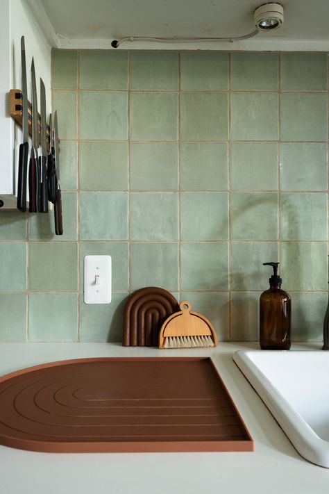 Kitchen with green square tile and white countertops Green Vertical Tile Backsplash, White And Green Tiles Kitchen, Pale Green Kitchen Backsplash, Green Zellige Tile Kitchen Backsplash, Green Tile Countertop, Kitchen Wall Tiles Green, Green Tile White Cabinets, Green Square Tiles Kitchen, Green Square Backsplash