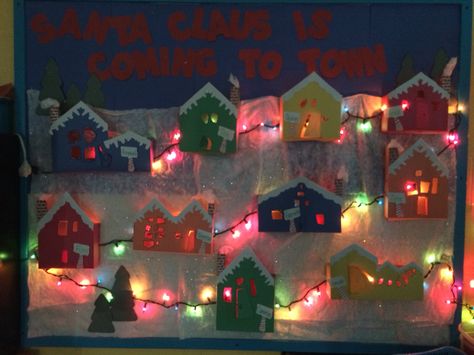 Santa Claus is coming to town!!  Children's village Christmas bulletin board. Winter Village Bulletin Board, December Window Display Preschool, Gingerbread Village Bulletin Board, Christmas Village School Hallway, Christmas Village Bulletin Board, Bulletin Board Winter, Winter Classroom Door, Door Decorations Classroom Christmas, Christmas Bulletin Boards