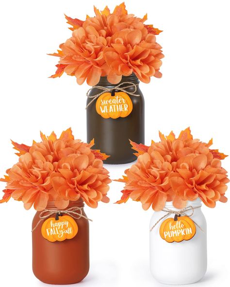 PRICES MAY VARY. Awesome Way to Decorate Your Table For Fall-This fall bouquet arrangement on the table will create new memories with your guests, the seasonable fall hues will fit the most autumn table, and you can add some harvest fruit around the arrangement to add vibrancy to the table. Pair with Pumpkin Slices & Faux Orange Greenery-The package contains 3 mason jars (brown, white, orange) tied with jute bowknots and comes with 3 pcs of pumpkin slices and 3 bunches of fall greenery, which ar Mason Jar Fall Centerpieces, Cheap Fall Decorations, Fall Centerpieces Wedding, Fall Dinnerware, Autumn Farmhouse, Table Floral Arrangements, Cheap Fall Decor, Halloween Mason Jars, Fall Mason Jars