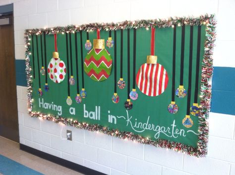 Christmas Bulletin Board - Christmas garland and lights, big ornaments made from bulletin board paper and paint and accented with ribbon, students colored ornaments. Hand painted words. Having a Ball in Kindergarten! School Christmas Board Ideas, Christmas Wreath Bulletin Board, Boletin Board For Christmas, Christmas Wall Displays Classroom, Office Christmas Bulletin Board, Christmas Gift Bulletin Board, Merry And Bright Bulletin Board Ideas, Christmas Bulletin Board Ideas For Daycare, Ornament Bulletin Board