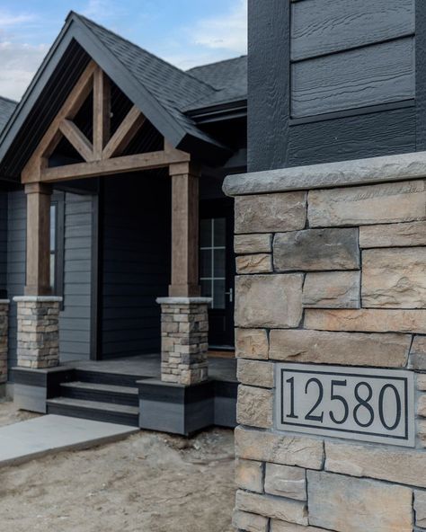 Wood Siding And Stone Exterior, Brick On Bottom Of House Exterior, Black And Stone Exterior House, Iron Ore And Stone Exterior, Deep Cavern Mastic Siding, Dark Grey Siding Black Windows, Dark Brown Barndominium Exterior, Black House With Stone, Dark Stone Exterior Houses