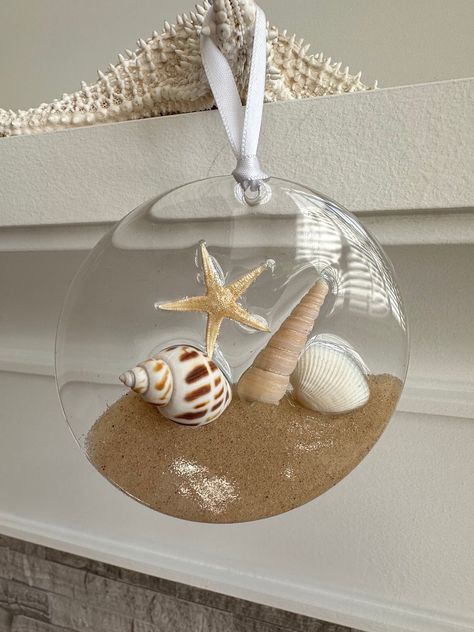 Beautiful acrylic disk ornaments. Many styles to pick from with real sand, starfish, shells and resin. Decorated with ribbons to hang. Ready to ship. Size is 4" The colour may vary due to lighting. This listing is for 1 ornament. Please be aware resin is a challenging substance to work with as it is very unpredictable. These pieces are handmade and may have micro bubbles and slight imperfections.  If you are not completly satisfied with your purchase, please dont hesitate to contact me. My goal Resin Beach Ornaments, Resin Shell Art, Resin Ornaments Diy, Disk Ornaments, Sand Starfish, Ocean Ornaments, Resin Ocean Art, Sand Dollar Art, Nautical Christmas Ornaments