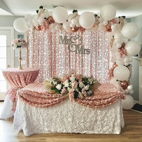 Set up a spectacular sweetheart table and install blush curtains on a backdrop stand. Further, set rose gold & white balloons on it adding white & blush wisteria garlands in between. Dress up the main table & cocktail table with white & blush rosette tablecloths. Also, set gold crystal beaded candelabras & flaunt white & blush roses along with blush wisteria, green, & gold palm leaves at the center of the main table & on the gold stand placed on the cocktail table to exude a lovely vibe. Gold White Balloons, Rosette Tablecloth, Gold Palm Leaves, Sweetheart Table Backdrop, Blush Curtains, Event Decor Ideas, Party Decorations Table, Sweetheart Table Decor, Main Table