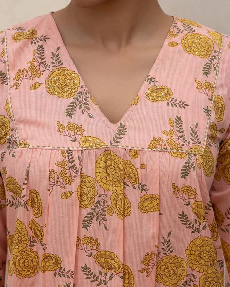 Summer 2024 - New Arrivals! The Peach V-Neck Kurta is a tea-party favourite from our Zinnia Blossom collection! This peachy set features mustard yellow flowers, striking pleats and elegant ladder lace inserts that give it a subtle definition. [ Cottons Jaipur, New Arrivals, Cotton, Floral, Handmade Kurtas, Everyday-wear, Summer staples ] #cottons #cottonsjaipur #newarrivals #floral #summer #summer2024 #handcraftedkurtas #comfortfits #cottonsuitset #summertime #summerstaples #summerfloral ... Cottons Jaipur, Pleated Dresses, Dress Models, Hanuman Ji, Cotton Kurti, Boutique Stores, Clothes Women, Lace Insert, Kurta Designs