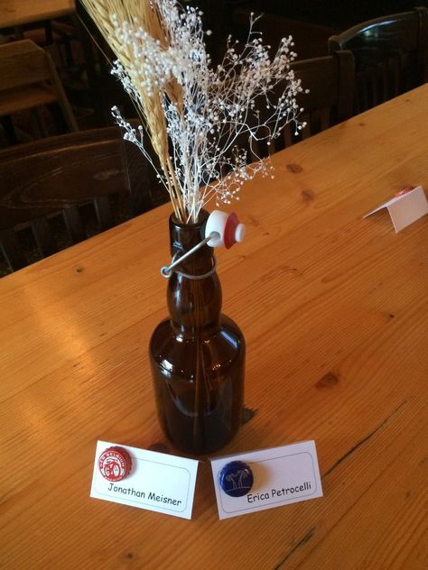 Swing-top beer bottles make the perfect centerpieces for this brewery rehearsal dinner. Bottle caps on the placecards complete the theme! #breweryrehearsal #oldemecklenbergbrewery #charlotte Rehearsal Dinner At Brewery, Brewery Engagement Party, Brewery Rehearsal Dinner, Beer Bottle Decor, Brewery Decor, Rehearsal Dinner Inspiration, Wedding Shower Food, Beer Dinner, Rehearsal Dinner Decorations