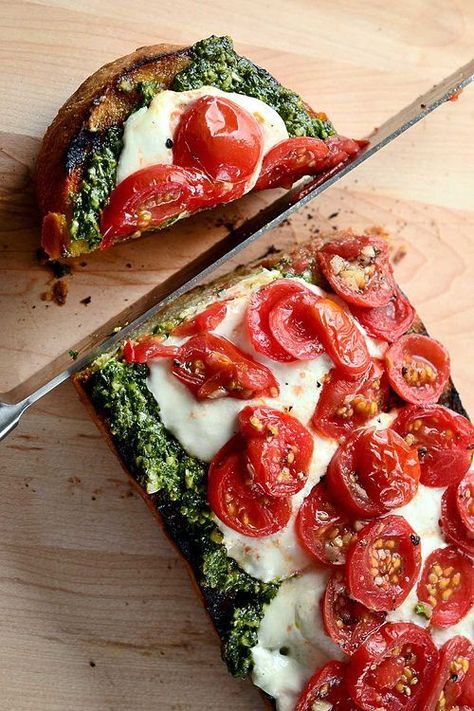 Bruschetta con Pesto, Pomodorini e Burrata - Preheat the oven to 350 degrees. Coat one half loaf Italian or Ciabatta bread with olive oil, then rub with a cut garlic clove. Bake until light golden brown. Remove from oven and top with your favorite pesto, sliced burrata cheese and cherry tomatoes. Bake until cheese is melted and tomatoes are slightly roasted. Slice and serve. Sandwich Vegetarian, Grilled Bread, Salad Pasta, I Love Food, Appetizer Snacks, Italian Recipes, Food Inspiration, Pesto, Love Food