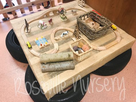 Small world provocation. Loose parts. Table made from tyres and pallet wrapped in hessian.  https://www.facebook.com/roseville.community.nursery Pallet Classroom Ideas, Eyfs Pallet Ideas, Loose Parts Table, Daycare Office Ideas, Hygge Eyfs, Ice Artwork, Nest Room, Preschool Layout, Babies Activities