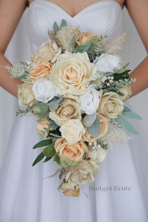 This lovely assortment of champagne, white, cream and sad is bound to turn heads on your wedding day. This lovely cascading brides’ bouquet from the is an absolutely breathtaking arrangement for any bride to be, in any season. Sage greenery and pampas grass complete the look and add a delicate realism to this beautiful bouquet. This bouquet is 10” wide, 18” long, and is crafted by our in-house florists without using a foam base to anchor the flowers to the bouquet. Instead, we wire our bouquets Bouquet With Pampas, Cream Wedding Bouquet, Small Bridesmaid Bouquets, Fake Wedding Flowers, Sage Eucalyptus, Cascading Wedding Bouquets, Classy Makeup, Fake Wedding, Fresh Wedding Flowers