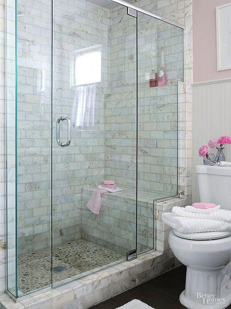 walk-in shower that enhances a usefulness and beauty. This shower stands out in a simply furnished bath, thanks to its distinctively tiled walls and river-rock-tiled floor that are easily seen through a frameless glass shower enclosure. The glass enclosure stair-steps up a marble frame, highlighting the shower bench and a toiletry shelf that aligns with the beaded-board wainscoting's upper trim. #BathroomShower Makeover Kamar Mandi, Små Rum Lidt Plads, Small Bathroom With Shower, Bad Inspiration, Master Bath Remodel, غرفة ملابس, Small Bath, Bathroom Redo, Shower Remodel