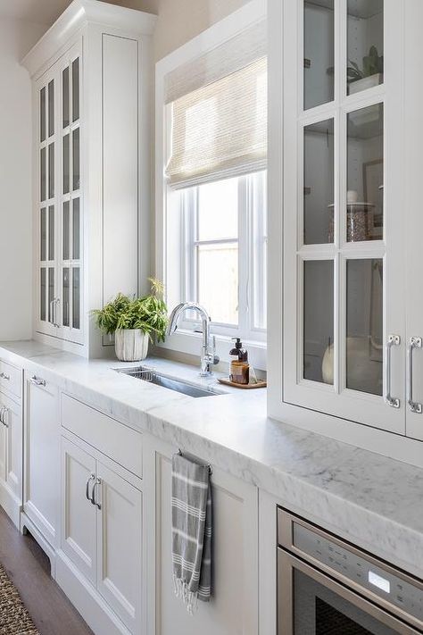 Glass Front Cabinets sit Atop Honed Marble Countertop - Cottage - Kitchen Cabinet Sitting On Countertop, Glass Front Kitchen Cabinets, White Beveled Subway Tile, Salt Interiors, Pure Salt Interiors, Beveled Subway Tile, Classic White Kitchen, Cottage Style Kitchen, Pure Salt