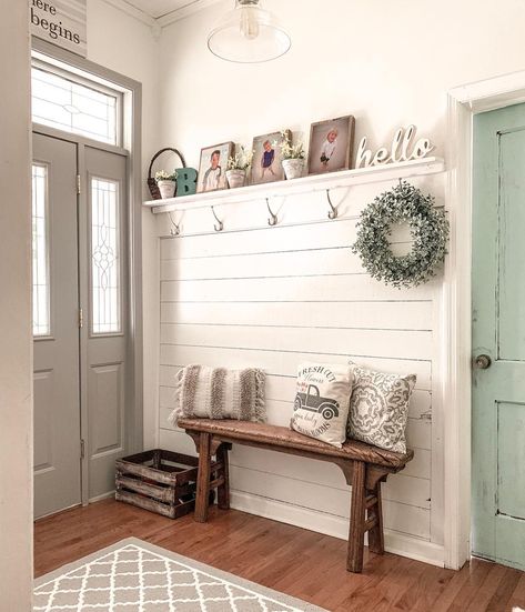 A row of silver coat hooks are mounted on white shiplap wainscoting above a narrow wooden entryway bench. The bench is placed in between a gray entryway door and a rustic light green interior door. Shiplap Entryway, Wood Entryway Bench, Farmhouse Mudroom, Laundy Room, Home Decor Apartment, White Shiplap Wall, Farmhouse Entryway, White Decorative Pillows, Home Decor Aesthetic