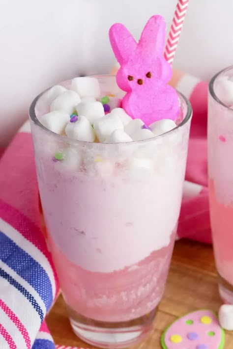 This delicious Easter punch recipe features a combination of sweet strawberry lemonade, creamy ice cream, and fizzy soda topped with mini marshmallows and a colorful peeps bunny. The festive punch is easy to make, filled with fruity flavors, and the perfect drink for your Easter celebration. Easter Party Drinks For Kids, Peep Punch, Bunny Punch, Easter Fluff, Easter Punch Recipes For Kids, Easter Bunny Punch, Easter Punch For Kids, Easter Drinks Non Alcoholic, Bunny Drink