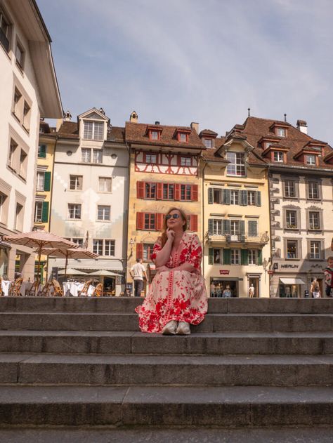 Nicola Lavin, travel blogger, sits on the steps of Kornmarkt in Lucerne Old Town during one day in Lucerne. Switzerland Lucerne, Lion Monument, Swiss Cuisine, Swiss Travel Pass, Swiss Travel, Lucerne Switzerland, The Alps, Lucerne, Europe Travel Tips