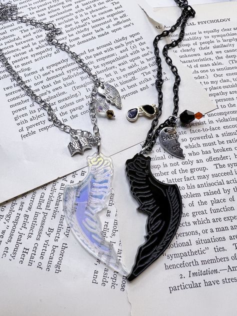 Crowley and Aziraphale are the best so I had to make them, best friend's necklaces. They are perfect to give to your friend or wear both of them. They each feature a now made of Acrylic charm of a wing. Azi is iridescent and Crowley's is black. Both are made by me. Crowley's has a black wing, a pair of hand-painted glasses, and a bead in black and red. He also has his partners in crime charm. Comes on a black chain. Aziraphale has an iridescent he has book charm, a bead in silver and gold with t Crowley And Aziraphale, Couples Necklaces, Handcuff Necklace, Book Charm, Bff Necklace, Bff Jewelry, Hand Painted Glasses, Ineffable Husbands, Bff Necklaces