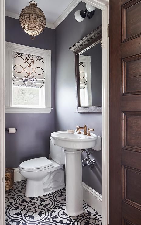 A black and white scroll roman shades hangs from a window in this purple Moroccan themed powder room lit by a gold lantern. Powder Room Paint Colors, Lavender Bathroom, Small Bathroom Window, Purple Bathroom Decor, Purple Bathroom, Purple Bedrooms, White Bathroom Decor, Purple Bathrooms, Pic Art