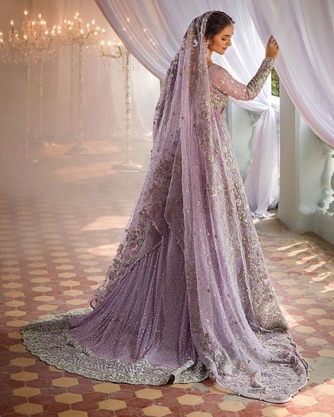 Make a luxurious statement on your special day with a masterpiece of opulence. This ensemble is lavishly adorned with intricate floral jaal patterns, heavily embellished with precision and care, and features intricately embroidered borders and a stunning neckline. Paired with a silver brocade sharara, finished with a beautiful floral border, and a lilac dupatta that shines with sequins and booti spray, this look is truly regal. The dupatta's borders are further embellished with handcrafted fl... Brocade Sharara, Front Open Gown, Full Sleeve Gowns, Bridal Sharara, Sharara Dress, Pakistani Bridal Dress, Nikah Dress, Yumna Zaidi, Walima Dress