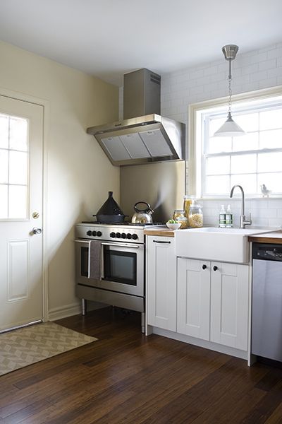 Beautiful kitchen with wide framed shaker front cabinets paired with oil-rubbed bronze hardware and butcher block countertops below a ceiling height subway tiled backsplash. The kitchen includes a footed stainless steel stove up against the wall which pairs with a stainless backsplash and stainless vent hood. An apron kitchen sink, Ikea Domsjo Sink Bowl, with gooseneck faucet stands beside the stainless steel dishwasher below the large kitchen window illuminated by a polished nickel pendant ... Stove Against Wall, Kitchen Sink Ideas, Back Splashes, Block Countertops, Best Kitchen Sinks, Kitchen Furniture Storage, Old Kitchen Cabinets, Sink Ideas, Butcher Blocks