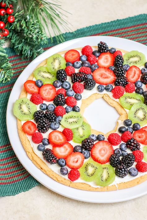 Make a sugar cookie fruit pizza in the shape of a wreath for the holiday season! This easy holiday dessert recipe will be the talk of the party! #christmas #holiday #dessert #yum #food #foodie #holidaydessert #christmasdessert #fruitdessert #fruit #sugarcookie #easyrecipe Fruit Pizza Christmas, White Macadamia Nut Cookies, Fruit Pizza Cookies, Holiday Dessert Recipes Easy, Fruit Sugar Cookies, Pizza Christmas, Sweet Pizza, Fruit Pizza Sugar Cookie, Fruit Pizza Recipe