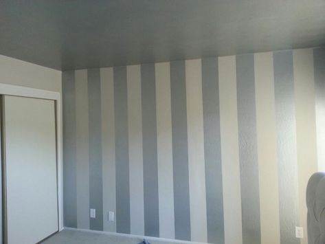 DIY painted vertical striped wall - gives tips for perfectly straight lines; no bleeding under the tape. Wall Painting Stripes, Striped Walls Living Room, Diy Interior Painting, Striped Walls Bedroom, Painted Stripes On Wall, Striped Walls Vertical, Gray Striped Walls, Painting Stripes On Walls, Stripe Wall