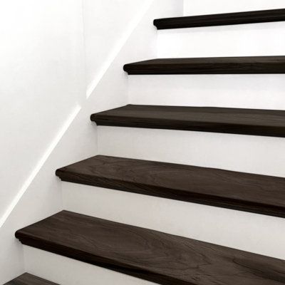 With modern, steely-grey hues and light knots and graining, Stair Tread Luxury Vinyl Tile adds style and elegance to a space. With MSI's Stair Tread, installation is easy, saving you time. There is no need to join a nose to a flooring plank, no join lines or gaps, and the finished look is professional and high-end. Use this gorgeous wood-look stair tread in the kitchen, living room, bathroom, or basement to create a seamless transition from floor to stairs. | MSI Luxury Vinyl Stair Tread Eased E Dark Wood Stairs With Runner, Lvp Flooring On Stairs, Vinyl Plank Stairs, Vinyl Plank Flooring On Stairs, Black Painted Stairs, Carpet On Stairs, Vinyl Stair Treads, Stairs Colours, Wood Stair Treads