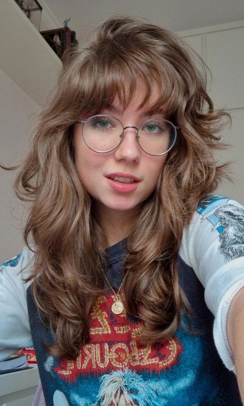 dark blonde hair, a lot of layers, medium length hair, bangs, round glasses Blonde Hair Dark Bangs, Bardot Bangs Curly Hair, Brown Hair With Highlights Bangs, Blonde Hair With Long Layers, Blonde Bangs Brown Hair, Trans Haircuts, Curtain Bangs With Glasses, Bangs With Glasses, Haircut Glasses