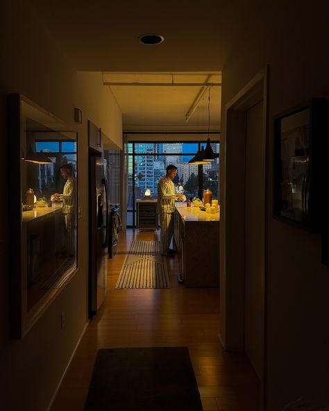 A cozy evening scene with warm lighting, prepping in a modern kitchen while the city skyline glows in the background—perfect blend of calm and urban vibes. Ambient Lighting Kitchen, Nyc Kitchen Apartment, Nyc Kitchen, Nyc Apt, Find Your People, San Francisco Houses, Living Place, Cozy Evening, Warm Lighting