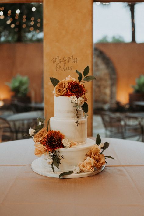 Fall in love with this jaw-dropping naked wedding cake adorned with the most captivating burnt orange, red, and green fall flowers. Your taste buds are in for a sweet treat at Agave Estates, the ultimate wedding venue in Katy, Texas. Photography: JoAnn Marie Photography #weddingcake #weddingvenue #venue #nakedcake #katytx #houston #wedding Fall Wedding Cake With Flowers, Sage Green And Burnt Orange Wedding Cake, Rustic Orange Wedding Cake, Burnt Orange Wedding Cakes, Green And Orange Wedding Cake, Earth Tone Wedding Cake, Wedding Cake With Fall Flowers, Wedding Cake With Orange Flowers, Burnt Orange Cake