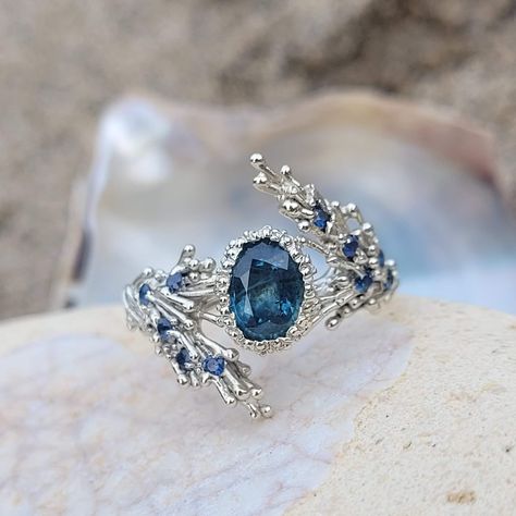 This statement white gold ring is inspired by ocean swells and underwater forests that can be found around the coastline of my native home on the island of Islay, off Scotland's west coast. Waves of seaweed details sweep on either side of the show stoppping ocean blue sapphire which is surrounded and set by a pool of delicate seafoam detail.  Tiny light blue sapphire accents have been embedded into the seaweed waves to add extra ocean sparkle. This is a one off piece so once its gone its gone. 9ct white gold 7x5mm blue sapphire 10x 1.5mm blue sapphires video link: https://www.instagram.com/p/CrBZdGWK9Jm/ Made on the Island of Islay & hallmarked in Edinburgh, Scotland Sea Inspired Engagement Rings, Ocean Themed Ring, Ocean Wedding Rings, Ocean Themed Rings, Sea Themed Accessories, Mermaid Wedding Ring, Ocean Ring Engagement, Ocean Inspired Wedding Rings, Ocean Inspired Ring