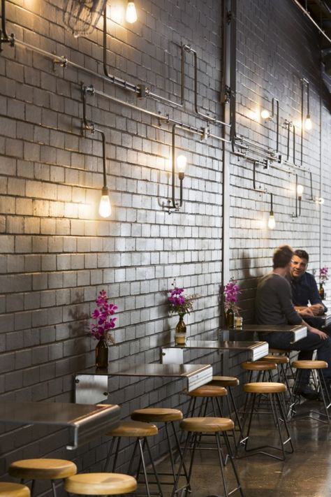 I picked this picture because I like the simplicity of the design.  The modern elements make the space feel industrial and sophisticate.  The bent metal as the table complements the colour of the wall while the warm wood stools warm up the space to balance the colder colours. Industrial Coffee Shop, Display Visual Merchandising, Café Design, Industrial Cafe, Industrial Coffee, Interior Vintage, Coffee Shops Interior, Modern Restaurant, Coffee Shop Design