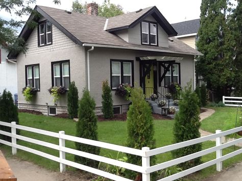 Remodeled 1918 craftsman home, black trim, taupe exterior (cliffside from Ace), citron green door, white 3 rail fencing, charming window boxes, love it! House Black Trim, Black Trim Exterior House, White Window Trim, Black Window Trims, Urbane Bronze, Paint Colors For House, Colors For House, Gray House Exterior, House Green