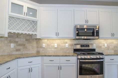 Love this kitchen with white cabinets and beige countertops and backsplash! We love that it also includes a wine and wine glass storage space #goals #designideas #kitchendesign #Balducci Builders, Inc. White Kitchen Cabinets With Beige Backsplash, White Kitchen Cabinets Beige Backsplash, White Cabinets Beige Countertops, Beige Backsplash Kitchen, Kitchen Modern Backsplash, Beige Tile Kitchen Floor, Kitchen Backsplash Beige, Beige Tile Kitchen, Beige Countertops