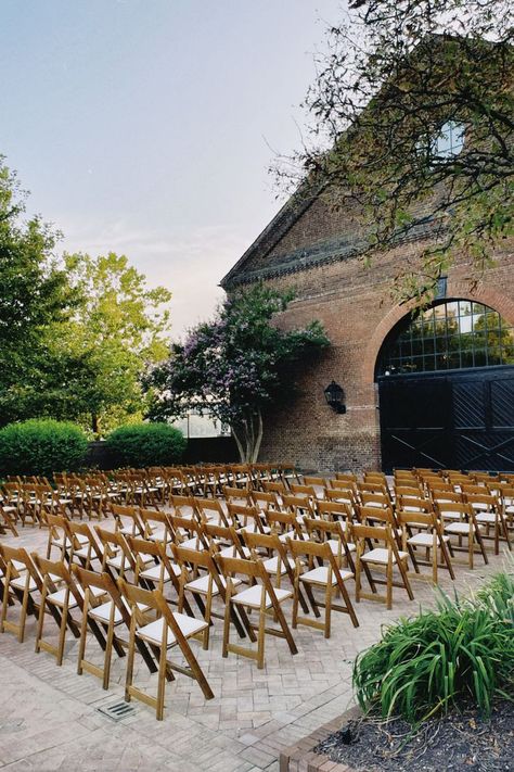 Chairs are set for a wedding ceremony at Tredegar Iron Works in Richmond, VA. The folding chairs are light brown with an off white cushion. The venue is brick with large black doors. Backdrop Wedding Ideas, Richmond Wedding, Marriage Material, Backdrop Wedding, Ceremony Seating, Ceremony Backdrop, Richmond Virginia, Wedding Planner, Virginia