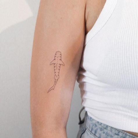 23 Shark Tattoo Ideas and Meanings - 2023 Guide Men’s Shark Tattoo, Cute Shark Tattoos For Women, Small Whale Shark Tattoo, Shark Tooth Tattoo Small, Small Shark Tattoo Simple, Shark Tattoo On Arm, Dainty Shark Tattoo, Small Tattoo Line, Simple Shark Tattoos For Women