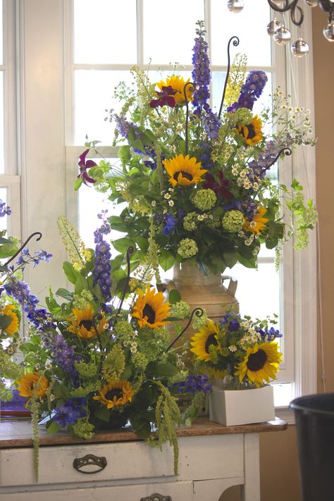 Sunflower arrangements on their way to the culinary garden at the Salamander Resort in Middle, VA. Includes Clematis vine, delphinium and green Viburnum. | J. Morris Flowers | Floral design studio with a passion for wedding and event decor, everyday floral designs, and floral education. We are located in downtown Leesburg, VA, and service the D.C. metro area and Loudoun County’s wine and hunt country Flower Arrangements Spring, Spring Flower Arrangements Centerpieces, Bouquet Champetre, Wedding Flowers Wildflowers, Sunflower Centerpieces, Sunflower Arrangements, Spring Flower Arrangements, Sun Flowers, Cemetery Flowers