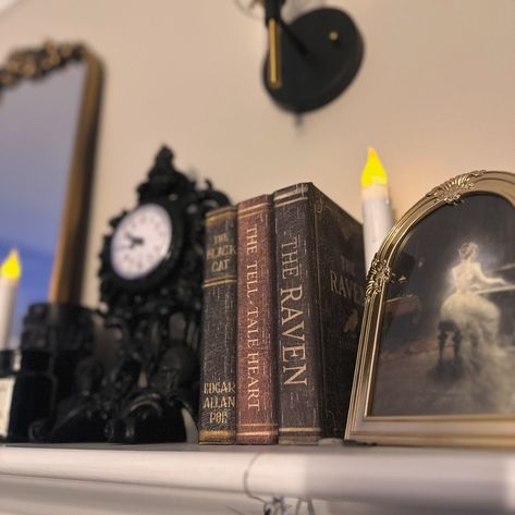 Stack of books 📚 for 100 Days of Halloween Happy 🖤 The current decor theme for my mantle is Dark Academia so this stack of Poe titles fit right in! The second picture is from before my living room was renovated - I still have the books displayed in my living room, just in different spots! #darkacademia #mantledecor #halloweenhomedecor #gothicdecor Dark Academia Mantle, Antique Library, Witchy Room, Fall Mantle Decor, Halloween Mantle, Fall Mantle, Dark Academia Decor, Bookcase Decor, My Living Room