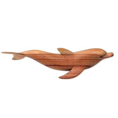 Eka pays tribute to the playful and intelligent bottle neck dolphins that swim off Lovino Beach on Bali's north coast. Carved by hand, the sleek marine mammal is depicted in a jempinis wood figurine. | Bay Isle Home™ Risher Realistic Artisan Carved Bottle Nose Dolphin Wood Figurine Wood in Brown, Size 4.0 H x 12.3 W x 3.5 D in | Wayfair | Home Decor | Black Friday / Cyber Monday Deals Bottle Nose Dolphin, Family Sculpture, Bottlenose Dolphin, Marine Mammals, Buy Wood, August 11, North Coast, Boho Chic Decor, Whittling