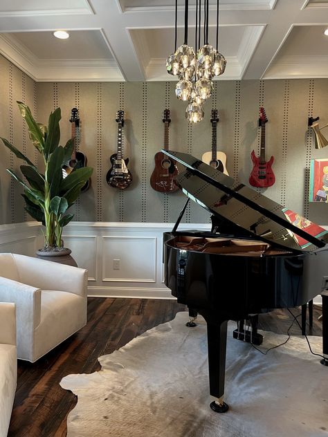 Music Room interior design. Piano on cowhide rug. Two side chairs. Vertical wallpaper design. Guitars hanging on wall. Coffered ceiling. Hanging globes chandelier. Music Room With Piano And Guitars, Piano Room Wallpaper, Nashville Interior Design, Rustic Music Room, Music Room With Piano, Music Room In House, Funky Music Room, Moody Music Room, Music Room Interior Design