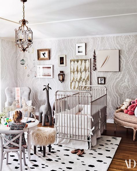 In Poppy's room, a wallpaper by Apparatus and ZAK + FOX hosts art by Hunt Slonem, Michael Hainey, Fernando Bengoechea, and Mary Little. A Julia Condon mobile hangs over an armchair by Cisco Home wearing a Mexican Otomi textile; crib, table, and chair by RH Baby & Child; Nate Berkus stool for Target; Caitlin Wilson rug. Baby Nursery Wallpaper, Nate And Jeremiah, Jeremiah Brent, Nate Berkus, Ideas Hogar, Los Angeles Homes, Nursery Wallpaper, Baby's Room, Step Inside