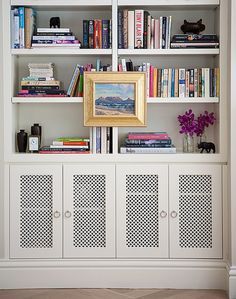 Make the bottom cabinet doors on the built-in like this with a decorative metal mesh to sort of 'hid' the electronics and put glass or plexi in there to keep the dog hair and dust out? Diy Radiator Cover, White Bookshelves, Living Tv, Bookcase Styling, Bookshelf Styling, Radiator Cover, Built In Bookcase, Built In Shelves, Front Room