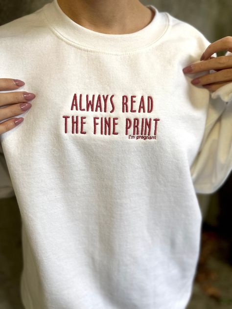 "\"Always read the fine print, I'm pregnant\" embroidered sweatshirt. Perfect cozy crewneck for a unique pregnancy announcement! Unisex sizing, size up for a true oversized look. Choose your sweatshirt color, and if you're looking for a different thread color message us to see if we have it :) 8 oz., 50% USA cotton, 50% polyester Pill-resistant air jet yarn Made with 50% sustainably and fairly grown USA cotton Read the fine print i'm pregnant sweatshirt, Read the fine print i'm pregnant embroidered sweatshirt, pregnancy announcement shirt, cute pregnancy announcement, i'm pregnant sweatshirt, pregnancy announcement, unique pregnancy announcement" Tell Him Youre Pregnant Ideas, Pregnant Announcement Shirt, Read The Fine Print Im Pregnant, Pregananant Announcement, Always Read The Fine Print Im Pregnant, We’re Pregnant Announcement To Family, Gifts For Pregnancy Announcement, Triplet Announcement Pregnancy, Pregnant Reveal To Family