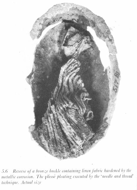 picture of the underside of a bronze brooch with strap remnants and pleated shift remnants from one of the Birka graves; from Geijer's article "The Textile Finds From Birka Graves" in Cloth and Clothing in Medieval Europe p. 88 (Heinemann Educational Books Ltd. 1983). The strap remains can be seen at the top - The Dreamstress Viking Apron, Ancient Textiles, Viking Clothes, Viking Apron Dress, Norse Clothing, Costume Viking, Viking Garb, Historical Costuming, Viking Dress