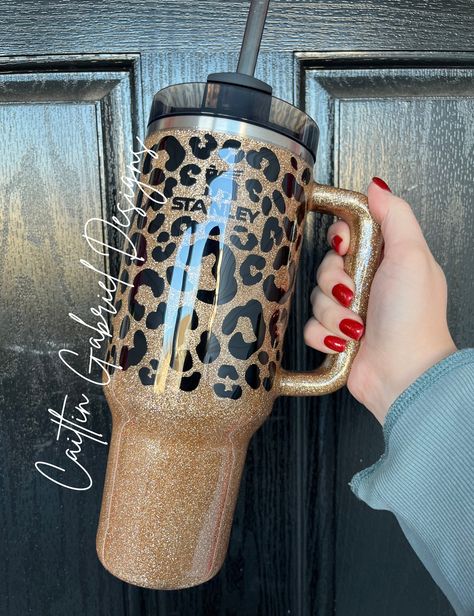 Leopard Print Tumbler  If you are wanting the cup in the LISTING PHOTO you MUST select the option "Stanley 40 oz" from the drop-down. I offer multiple cup styles with this design. If you have any questions feel free to reach out!  Unless otherwise requested Stanley and Simple Modern tumblers will be made using a black base cup. If you want something besides the gold/black please add it to the personalization box! I have a TON of glitter options as well as vinyl, so this is completely customizable.  The tumbler is sealed with epoxy to give a glass-like finish.  CARE INSTRUCTIONS: -HAND WASH ONLY -DO NOT MICROWAVE -DO NOT SOAK -NOT DISHWASHER SAFE -AVOID EXTREME TEMPERATURES -AVOID HARSH CHEMICALS  Due to the personalized nature of this product, returns/exchanges are not accepted. Please mak Glitter Stanley Cup, Blinged Cups, Bloxburg Food Decals, Leopard Print Tumbler, Leopard Tumbler, Stanley Cups, Grunge Accessories, Birthday Ideas For Her, Glitter Tumbler Cups