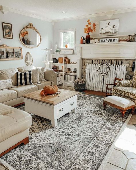 This living room features a cream corner sofa on a patterned rug and a fireplace blocked with white decorative fencing. Fall decor ideas in this space include a pumpkin on the table, a pumpkin print on the wall, and a sign reading 'harvest' on the mantel. Cream Corner Sofa, Fall Fireplace, Living Room Sets Furniture, Fall Porch, Farmhouse Style Decorating, Mustard Seed, I Did It, Autumn Home, Corner Sofa