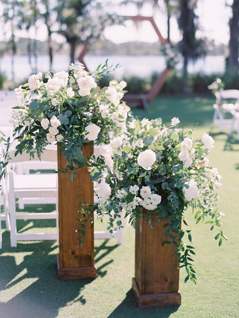 White and Green Floral Altar pieces in a garden style atop of natural wood stands. Wedding Aisle Columns, Floral Stand Wedding Ceremony, Wedding Ceremony Column Flowers, Ceremony Arrangements On Pedestals, Free Standing Wedding Ceremony Flowers, Floral Arrangements On Pedestals, Aisle Entry Flowers, Nature Wedding Ceremony Decor, Standing Floral Arrangements Wedding