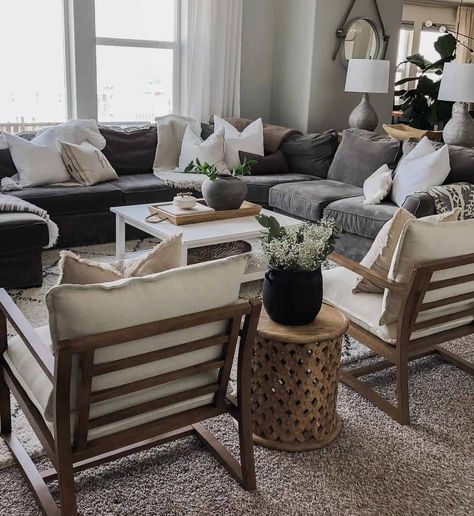 Round wooden lattice end table is perched between beige accent chairs with stained wood frames. The chairs face a square white living room coffee table placed in front of a grey sectional. White Living Room Table, Beige Accent Chairs, Grey Sectional Couch, White Chaise Lounge, Gray Sectional Living Room, Gray Sectional, Grey Couch Living Room, Black And White Living Room, Modern Farmhouse Living