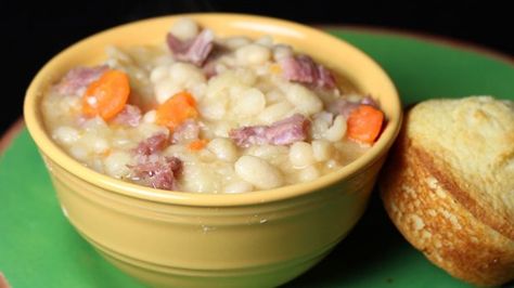 This recipe for a hearty ham white bean soup calls for carrots, celery, onion, bay leaves and mustard powder. Ham And Bean, Navy Bean Soup, Gravy Packet, Daniel Plan, Country Gravy, Ham Bone, Ham Soup, Ham And Beans, Ham And Bean Soup